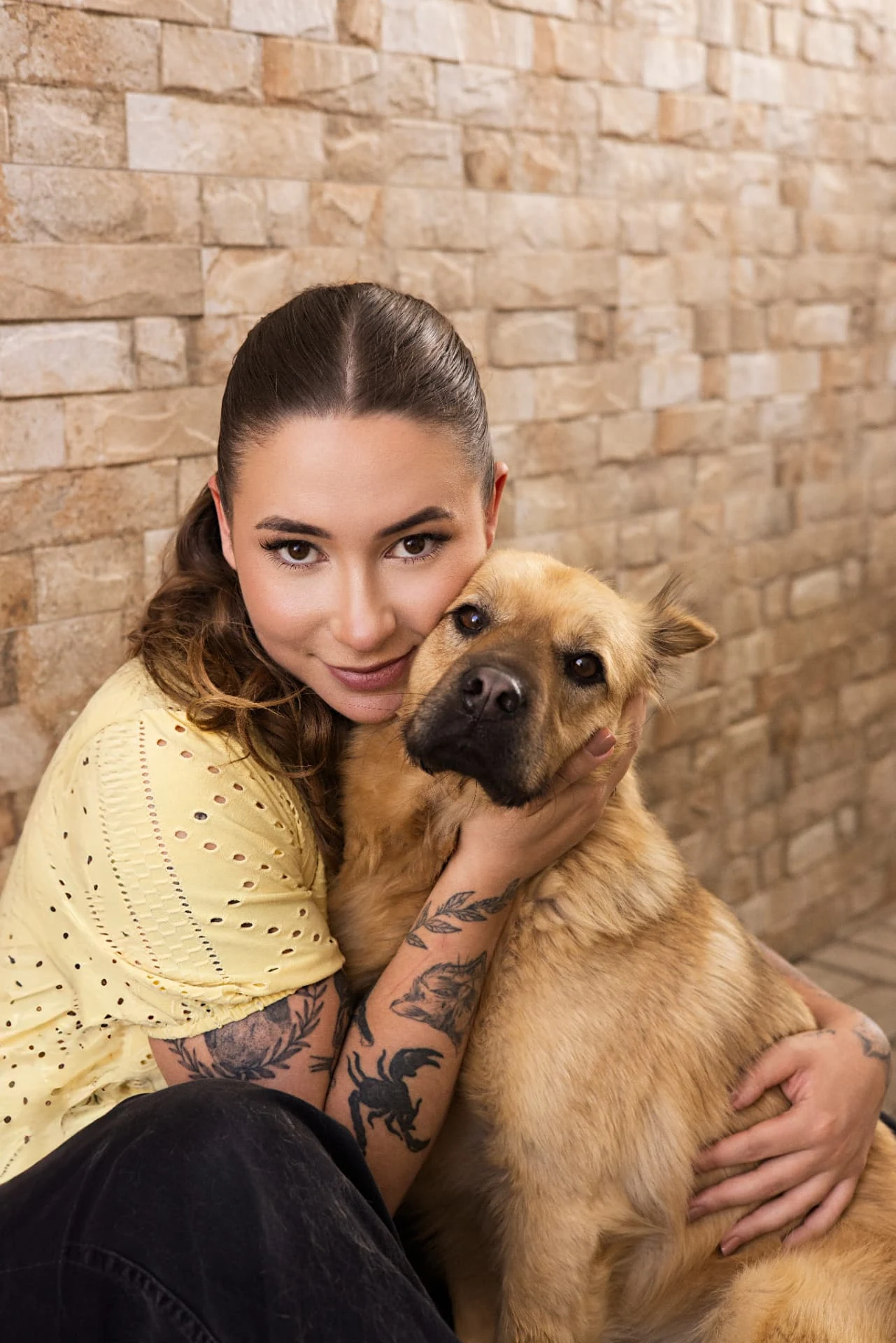 Letícia Fernandes abraçando um cão caramelo